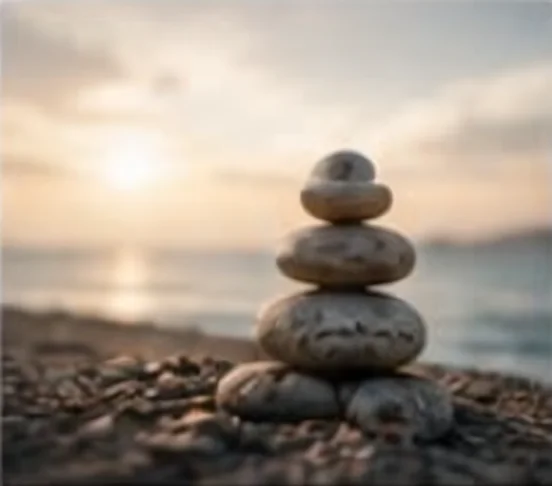 Smooth stones balanced on a beach at sunrise